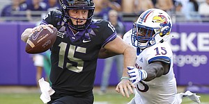 TCU quarterback Max Duggan, left, tries to scramble away from Kansas defensive end Kyron Johnson during the first half of an NCAA college football game Saturday, Nov. 20, 2021, in Fort Worth, Texas. (AP Photo/Ron Jenkins)