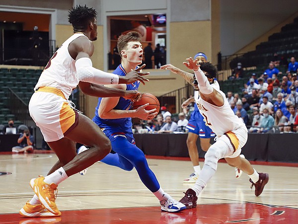 Iona forward Nelly Junior Joseph, left, and guard Elijah Joiner, right, guard against Kansas guard Christian Braun during the first half of an NCAA college basketball game Sunday, Nov. 28, 2021, in Lake Buena Vista, Fla. (AP Photo/Jacob M. Langston)