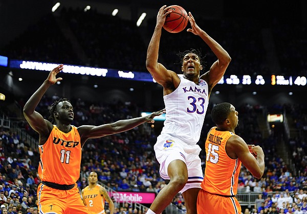 Kansas forward David McCormack (33) gets a pass in the paint over UTEP Miners forward Alfred Hollins (15) during the first half on Tuesday, Dec. 7, 2021 at T-Mobile Center in Kansas City. Also pictured is UTEP Miners forward Bonke Maring (11).