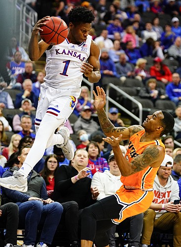 Kansas guard Joseph Yesufu (1) tries to save an out-of-bounds ball by throwing against UTEP Miners guard Christian Agnew (2) during the first half on Tuesday, Dec. 7, 2021 at T-Mobile Center in Kansas City.