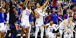 The Kansas bench erupts after a made three-pointer by reserve Michael Jankovich (20) with seconds remaining in the game on Tuesday, Dec. 7, 2021 at T-Mobile Center in Kansas City.