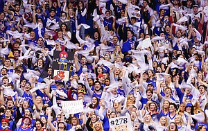 Fans in the student section swing towels as the Jayhawks take the court on Saturday, Dec. 11, 2021, at Allen Fieldhouse.