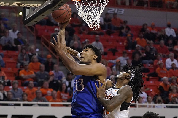 Kansas forward David McCormack (33) shoots in front of Oklahoma State forward Kalib Boone, right, in the second half of an NCAA college basketball game Tuesday, Jan. 4, 2022, in Stillwater, Okla. (AP Photo/Sue Ogrocki)