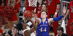 Texas Tech's Adonis Arms (25) shoots the ball around Kansas' Mitch Lightfoot (44) during the first half of an NCAA college basketball game on Saturday, Jan. 8, 2022, in Lubbock, Texas. (AP Photo/Brad Tollefson)