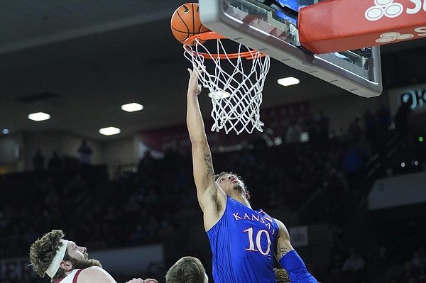 Kansas forward Jalen Wilson shoots in front of Oklahoma forward Tanner Groves, left, in the second half of an NCAA college basketball game Tuesday, Jan. 18, 2022, in Norman, Okla. (AP Photo/Sue Ogrocki)
