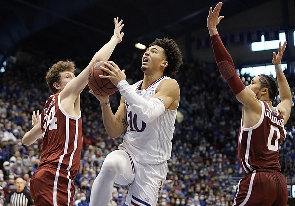 Kansas forward Jalen Wilson (10) elevates to the bucket between Oklahoma forward Jacob Groves (34) and Oklahoma guard Jordan Goldwire (0) during the second half on Saturday, Feb. 12, 2022 at Allen Fieldhouse.