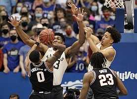 Kansas forward David McCormack (33) and Kansas forward Jalen Wilson (10) swarm Oklahoma State guard Avery Anderson III (0) during the second half on Monday, Feb. 14, 2022 at Allen Fieldhouse.