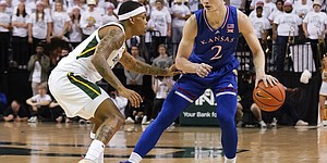 Kansas guard Christian Braun, right, runs the offense as Baylor guard James Akinjo defends during the first half of an NCAA college basketball game Saturday, Feb. 26, 2022, in Waco, Texas.