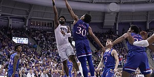 TCU guard Mike Miles (1) goes up for a shot as Kansas guard Ochai Agbaji (30) defends in the second half of an NCAA college basketball game in Fort Worth, Texas, Tuesday, March 1, 2022. (AP Photo/Tony Gutierrez)