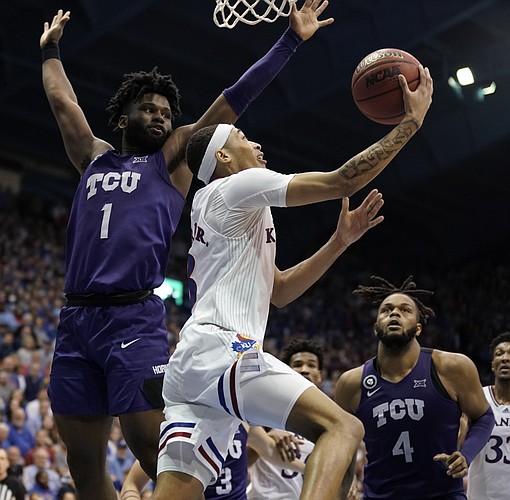Kansas guard Dajuan Harris Jr. (3) gets past TCU guard Mike Miles (1) for a reverse layup late in the second half on Tuesday, March 3, 2022 at Allen Fieldhouse.