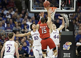 Kansas forward Jalen Wilson (10) and Kansas forward Mitch Lightfoot (44) defend against a shot from Texas Tech guard Kevin McCullar (15) during the first half of the Big 12 Tournament championship game on Saturday, March 12, 2022 at T-Mobile Center in Kansas City.