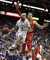 Kansas guard Dajuan Harris Jr. (3) looks to whip a baseline pass as he is defended by Texas Tech forward Marcus Santos-Silva (14) during the second half of the Big 12 Tournament championship game on Saturday, March 12, 2022 at T-Mobile Center in Kansas City.