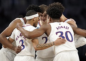 The Jayhawks come together in a huddle during the first half on Saturday, March 19, 2022 at Dickies Arena in Fort Worth, Texas.