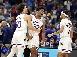 Kansas forward David McCormack (33) celebrates with Kansas forward Jalen Wilson (10) and Kansas guard Dajuan Harris Jr. (3) after an and-one bucket during the second half on Sunday, March 27, 2022 at United Center in Chicago. The Jayhawks defeated the Hurricanes, 76-50 to advance to the Final Four.