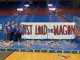 Kansas coach Bill Self, second from left, is joined by his sister, Shelly Anderson, left, his wife, Cindy, and his mother, Margaret, by the new banner that hangs in Allen Fieldhouse to honor a favorite phrase of his father's, Bill Self Sr., who died in late January at 82. 