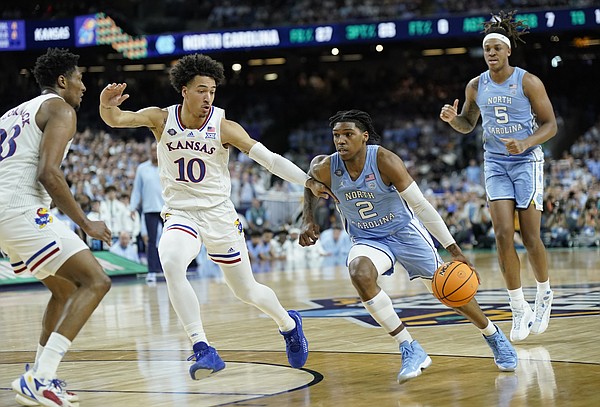 Kansas forward Jalen Wilson (10) defends against a drive from North Carolina guard Caleb Love (2) during the first half of the NCAA National Championship game on Monday, April 4, 2022 at Caesars Superdome in New Orleans.