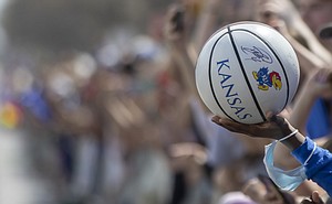 A fan holds out a KU basketball in hopes of having a KU player sign it during a parade to celebrate the KU men’s basketball team’s NCAA basketball championship Sunday, April 10, 2022.