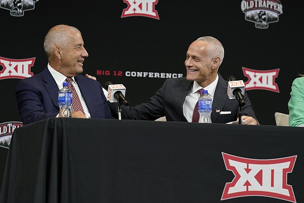 Incoming Big 12 Commissioner Brett Yormark, right, shares a laugh with outgoing Commissioner Bob Bowlsby at a news conference opening the NCAA college football Big 12 media days in Arlington, Texas, Wednesday, July 13, 2022. (AP Photo/LM Otero)