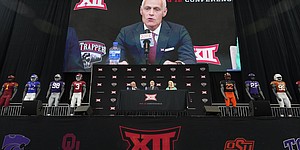 Incoming Big 12 Commissioner Brett Yormark, center, speaks with outgoing Commissioner Bob Bowlsby, left, and Baylor President Linda Livingstone looking on during a news conference opening the NCAA college football Big 12 media days in Arlington, Texas, Wednesday, July 13, 2022. (AP Photo/LM Otero)