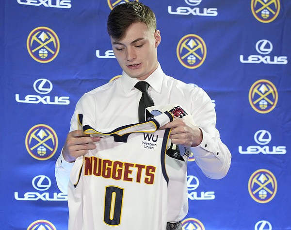 One of the Denver Nuggets' selections from the NBA Draft, Christian Braun, looks over his jersey after being introduced to the media during a news conference Monday, June 27, 2022, in Denver. (AP Photo/David Zalubowski)


