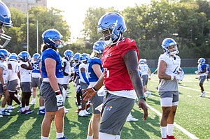Kansas junior quarterback Jalon Daniels (6) high fives his teammates during the first day of practice on Tuesday, Aug. 2, 2022.