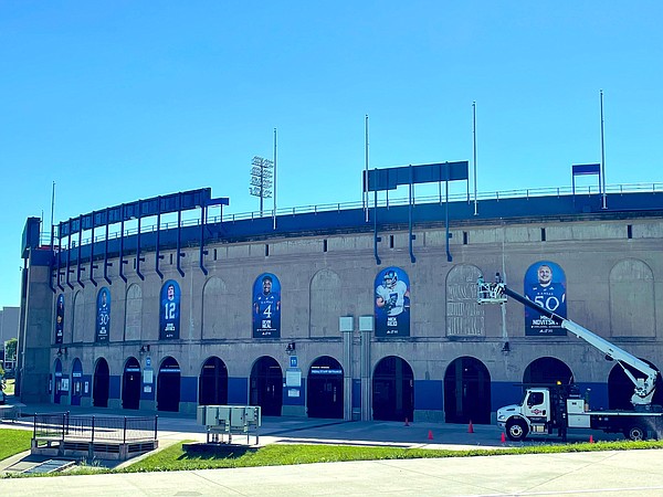New images of current and former Kansas football players were being put up on the outside of David Booth Kansas Memorial Stadium on Tuesday morning. 