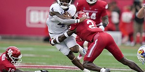 Kansas running back Devin Neal (4) is tackled by Houston defensive back Gervarrius Owens (2) during the first half of an NCAA college football game, Saturday, Sept. 17, 2022, in Houston. (AP Photo/Eric Christian Smith)