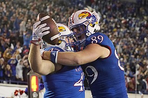 Kansas hardside Jared Casey (47) was congratulated by teammate tightside Mason Fairchild (89) after scoring a two-yard overtime goal in the second half of the Liberty Bowl NCAA college football game Wednesday, December 28, 2022.  Arkansas won 55-53 in three overtimes in Memphis, Tenn.  (AP Photo/Rogelio V. Solis)
